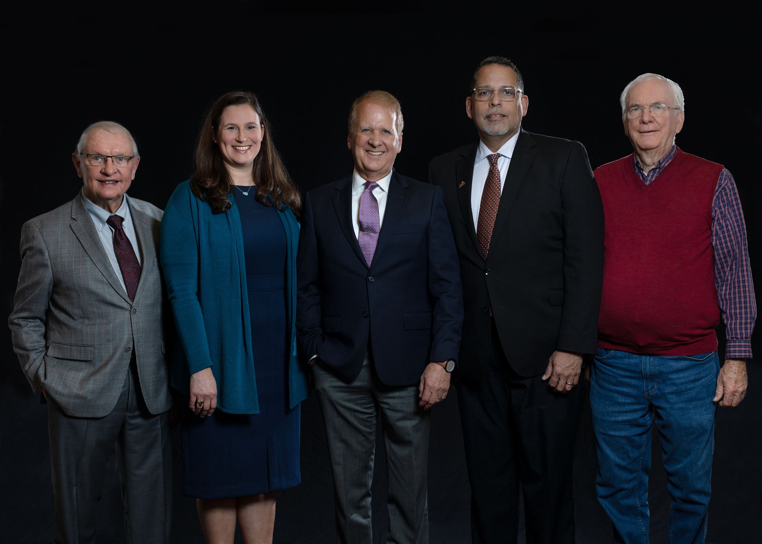 Professional group portrait of lilburn city council members in suits on black backdrop