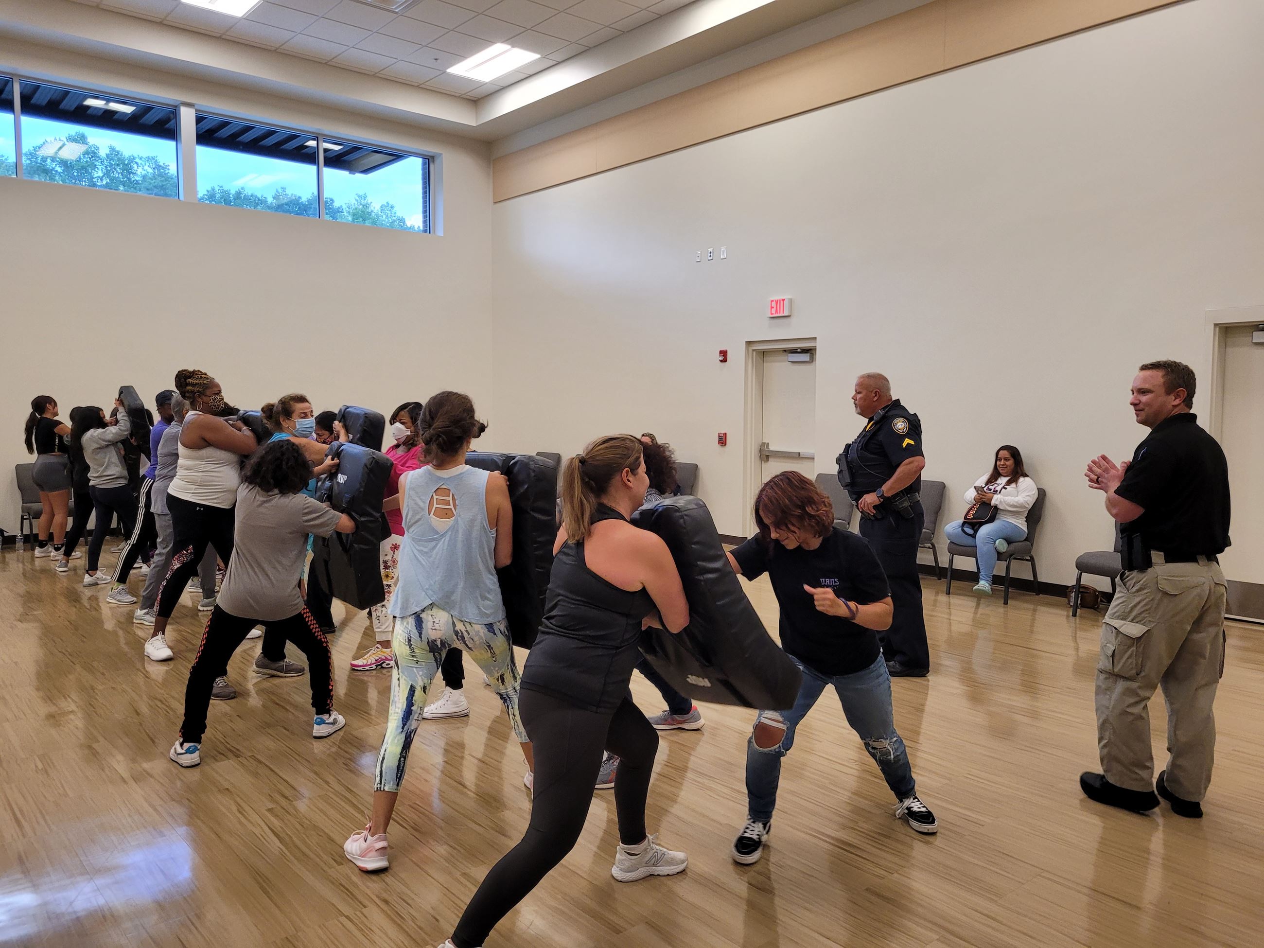 women in a gym in a line with boxing shields