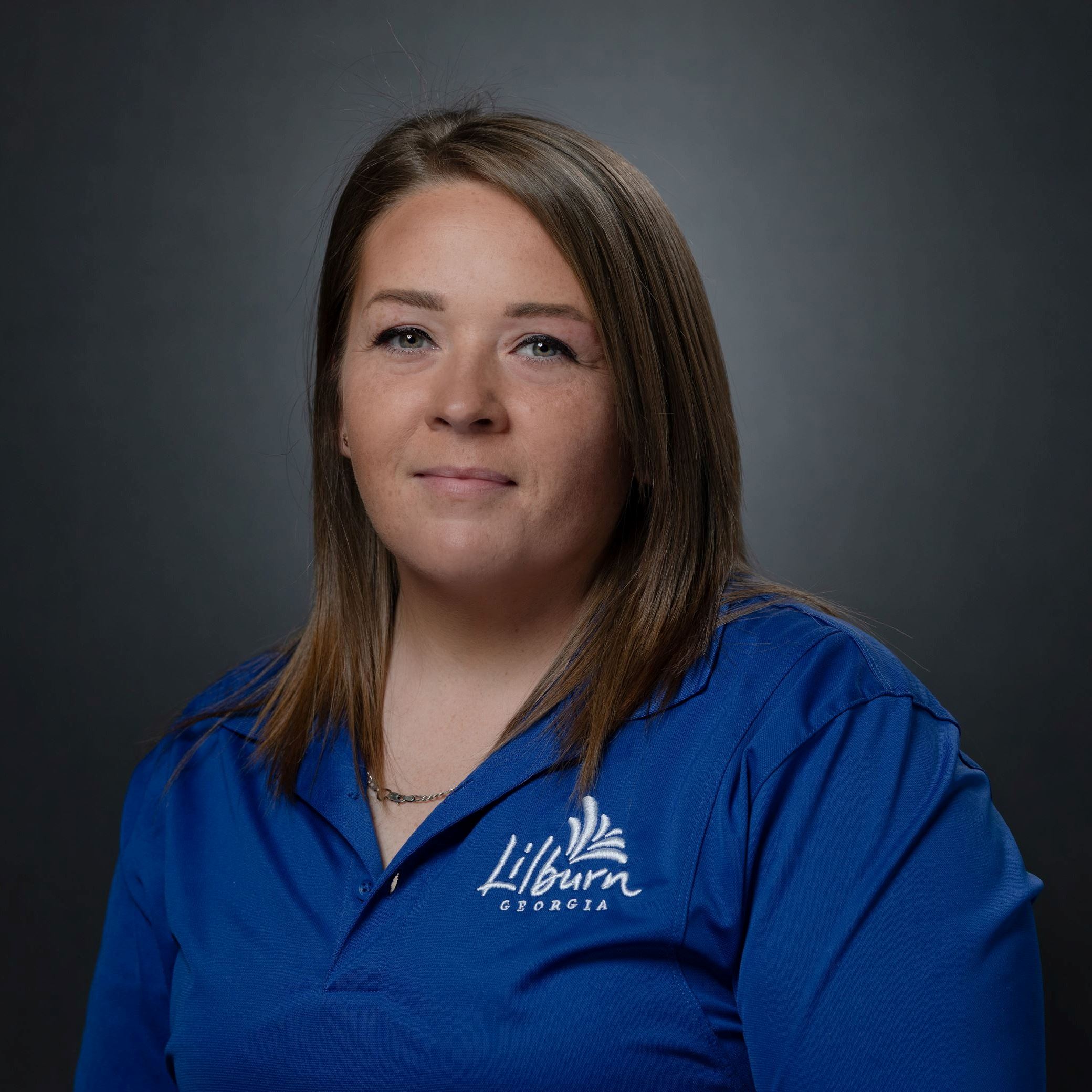 April Hill Headshot - Female with shoulder length hair and blue shirt