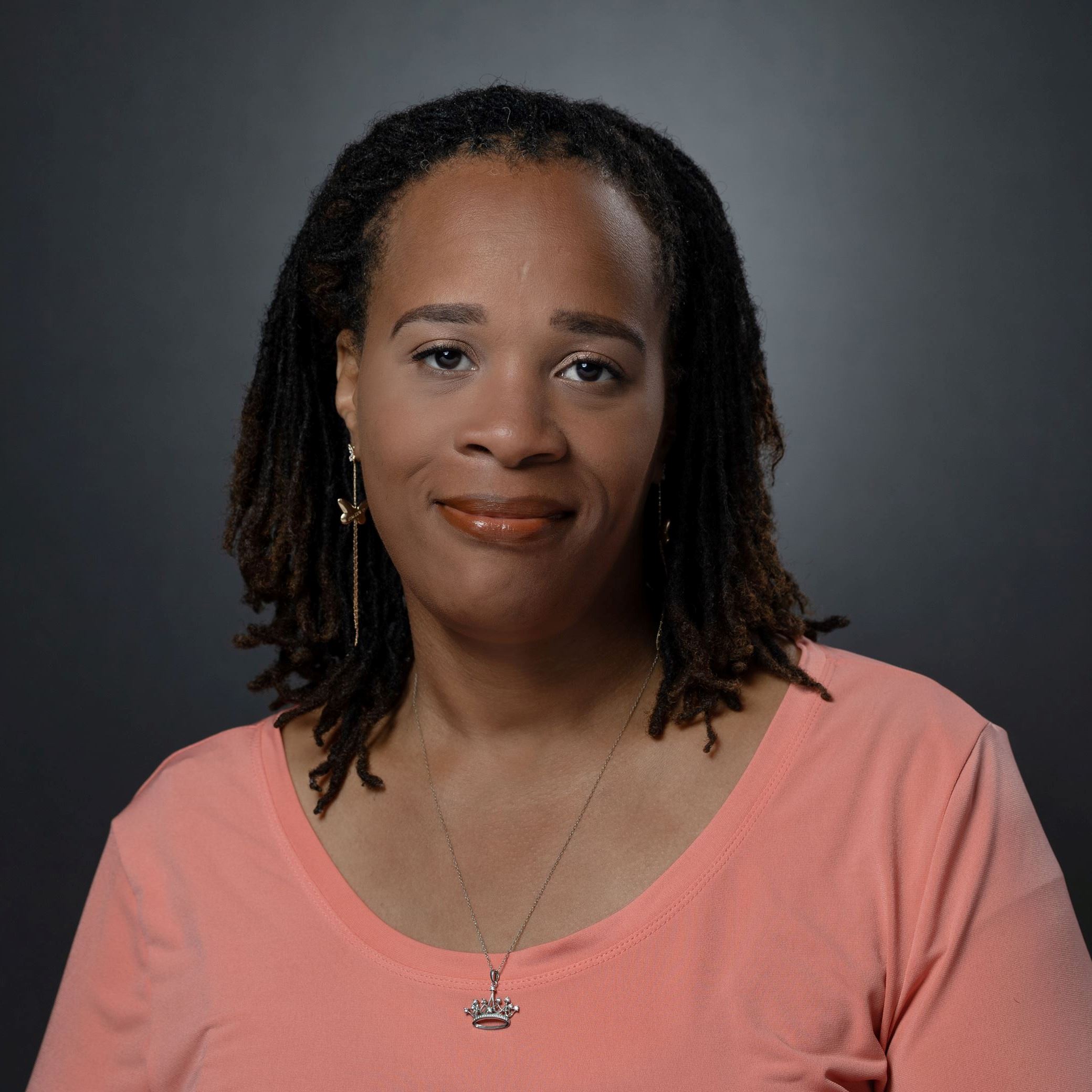 Headshots Latonya Koonce female with shoulder length black braided hair wearing peach shirt