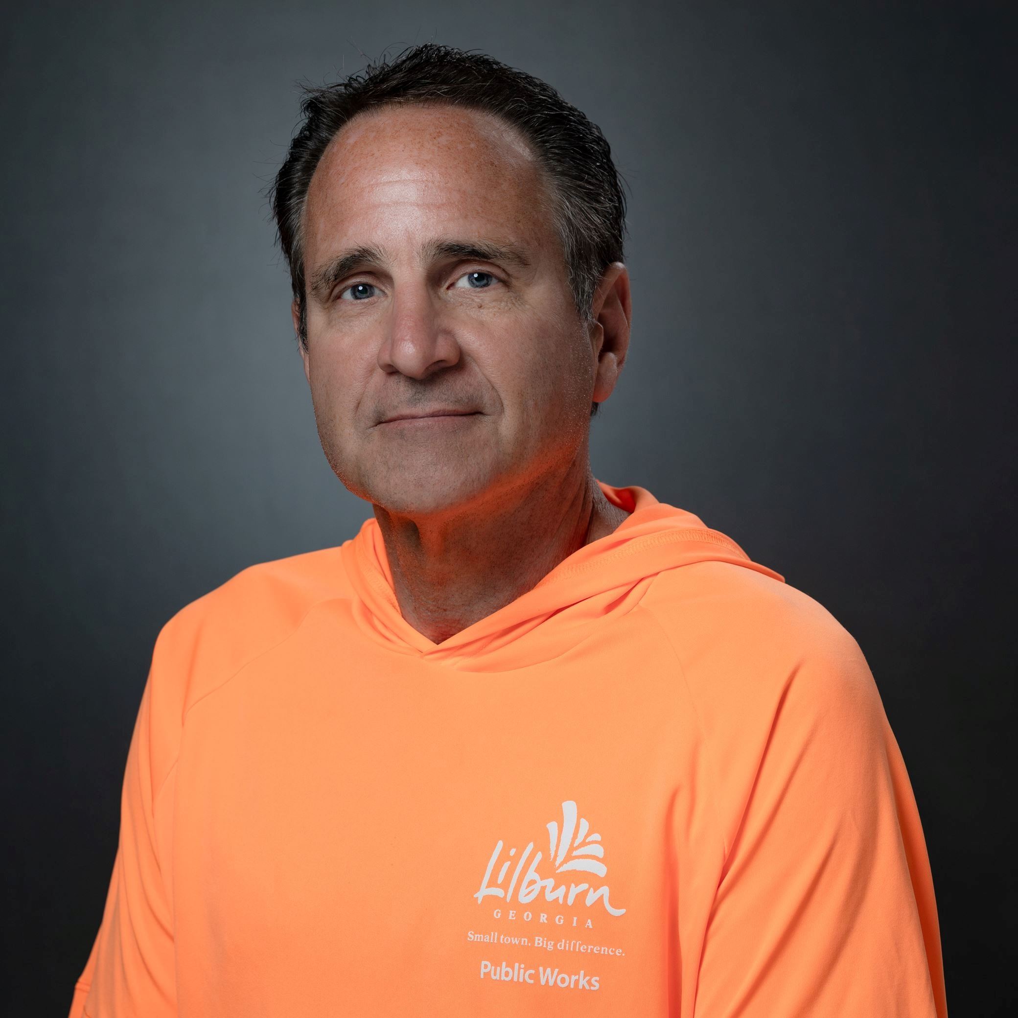 Headshots of Robby Johnston male with short dark hair wearing orange long sleeve tee