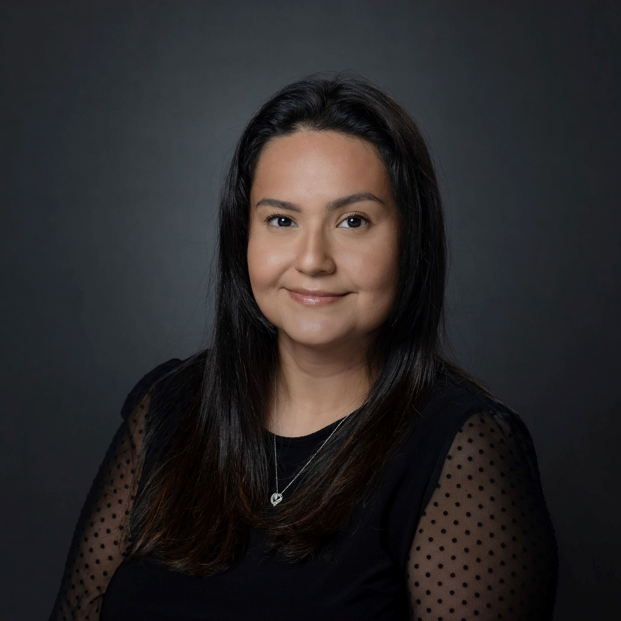 Headshot of Leticia Suarez female with long dark hair wearing black blouse