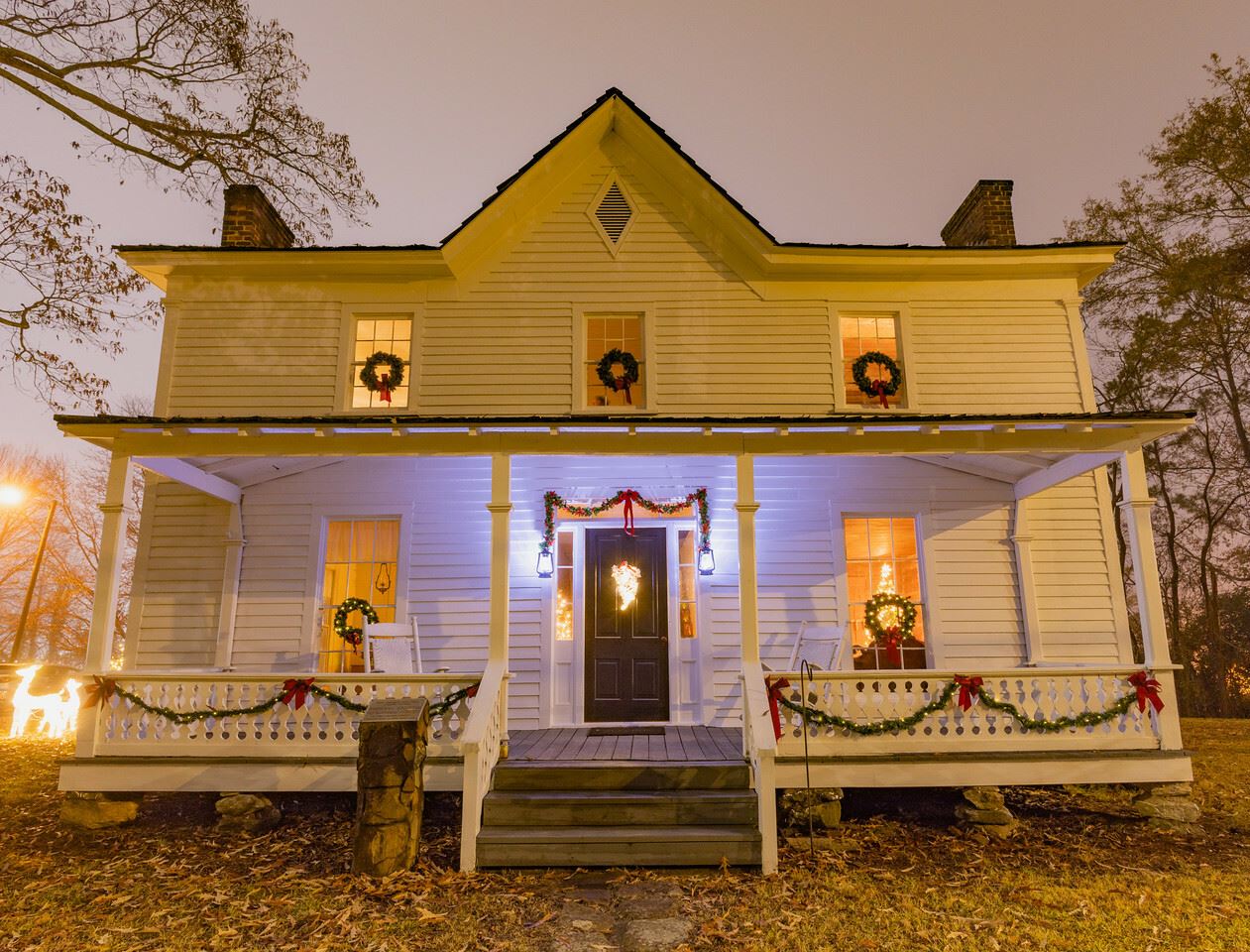 historic white house with porch and christmas wreaths